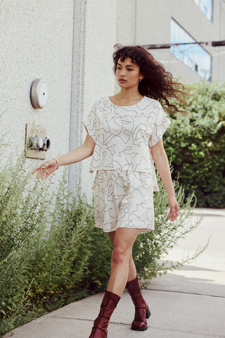 Short court et fluide à la taille élastique. Imprimé lignes noires sur fond crème réalisé par l'artiste montréalaise Alice Picard. Fait à Montréal.
